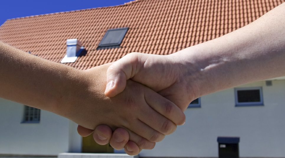 Zwei Männer geben sich die Hand nach einer erfolgreichen Sanierungsberatung.