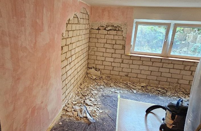 Öffnung der Wand bis zum Mauerwerk für eine Feuchtigkeitssanierung.