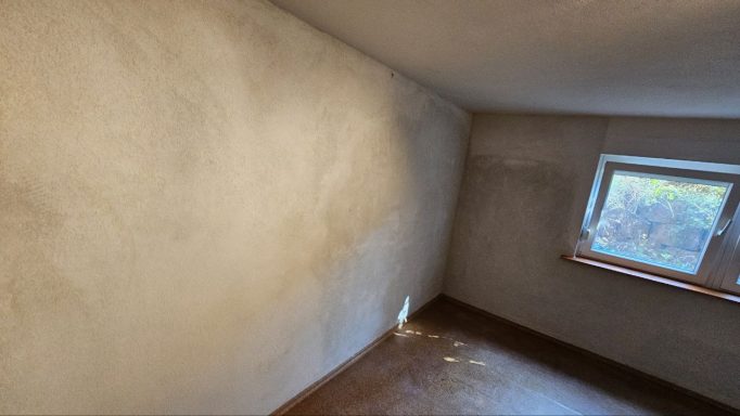 Mauer mit aufgetragenem Sanierputz gegen Feuchtigkeit nach einer Mauerwerkssanierung.