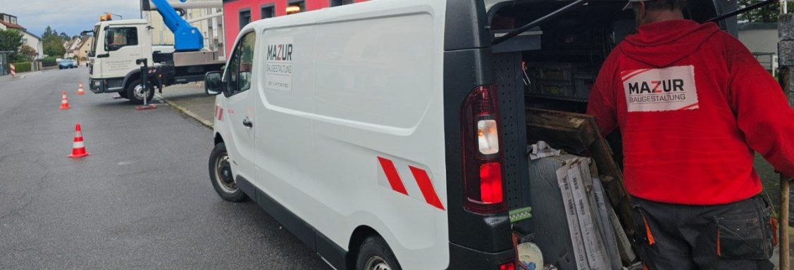 Transporter mit geöffneter Tür, Arbeiter holt Material heraus, Absperrung im Hintergrund.